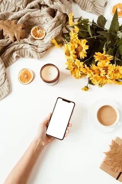 A person placing their smartphone face down on a wooden table in a sunlit room. The room is decorated with calming elements like plants and candles to evoke relaxation.