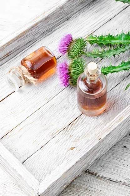 Close-up shot of various essential oil bottles arranged neatly on a wooden tray, with water droplets on the glass. The oils are of different colors, and the labels are visible, showcasing names like lavender, eucalyptus, and peppermint.
