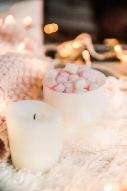 A close-up of a lit aromatherapy diffuser surrounded by small candles, creating a warm, inviting glow and filling the air with a calming fragrance.