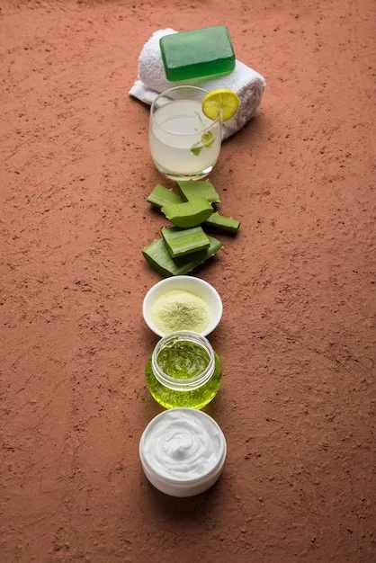 A close-up photo of various natural skincare ingredients, such as aloe vera, shea butter, and green tea leaves, arranged on a wooden surface. Soft, natural light highlights the textures and colors of the ingredients.