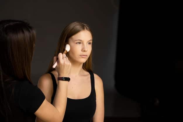 A woman demonstrating how to blend highlighter on her cheekbone using a soft brush, with a focus on achieving a seamless, natural finish. The lighting highlights the blended area.