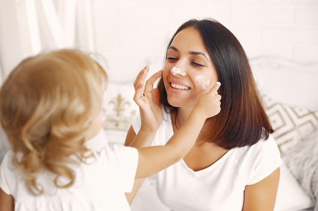 A US mom applying moisturizer to her face in front of a mirror, with sunlight streaming in softly. She is smiling gently.