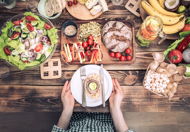 A table setting featuring a mix of both healthy and unhealthy food choices. On one side, fresh fruits, vegetables, and whole grains; on the other side, processed snacks, sugary drinks, and fried foods, visually illustrating the contrast between skin-friendly and skin-damaging diets.