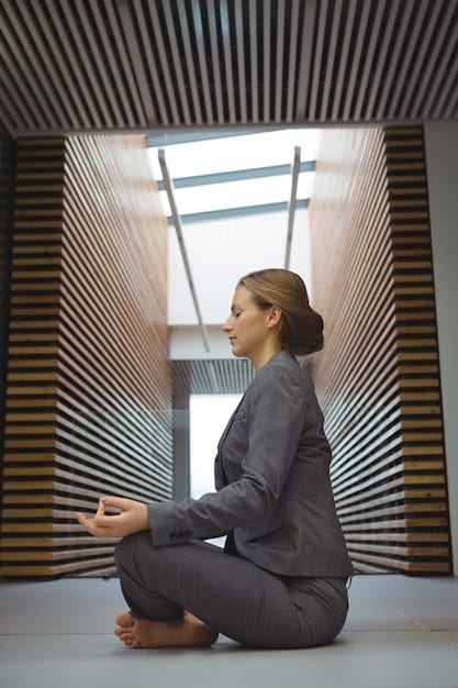 A person sitting cross-legged in a modern office space, meditating. The background shows blurred office activities, emphasizing the contrast between the calm individual and the busy environment. Soft, diffused lighting adds to the serene atmosphere.