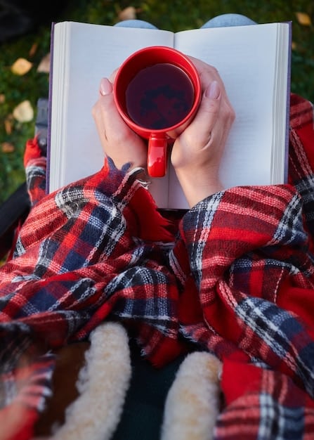 A person journaling outdoors in a peaceful park on a sunny Sunday, with a cup of tea and a cozy blanket, capturing a moment of reflection and tranquility.