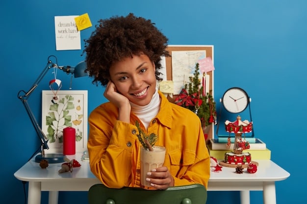 A person smiling while carefully cutting out images from magazines for their vision board, surrounded by art supplies and a cup of tea.