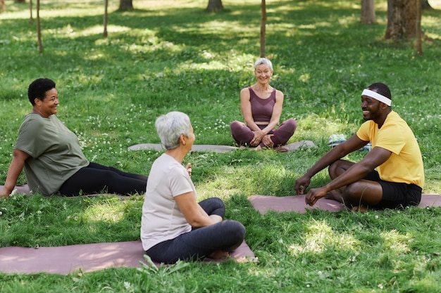 A diverse group of people doing yoga in a park, focusing on their movements and breathing rather than their appearance.