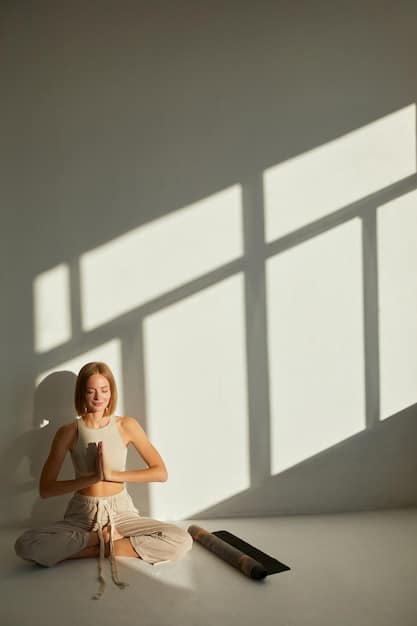 A person practicing yoga in a bright studio, surrounded by natural light. They are smiling and appear relaxed, emphasizing the connection between mental and physical well-being.