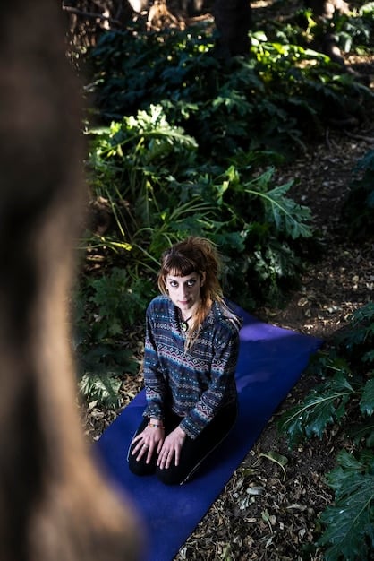 A person practicing yoga outdoors in a serene environment, focusing on their breath and inner peace. The image emphasizes the connection between physical activity, mindfulness, and positive body image.
