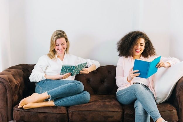 Two women sitting on a couch, laughing and reading a book together. They both have different body types and are dressed comfortably. The scene is warm and inviting, emphasizing their friendship and acceptance of each other.