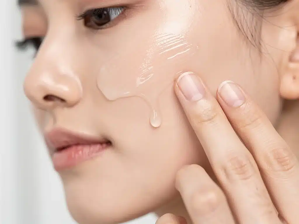 Person applying anti-acne serum during a daily skincare routine.